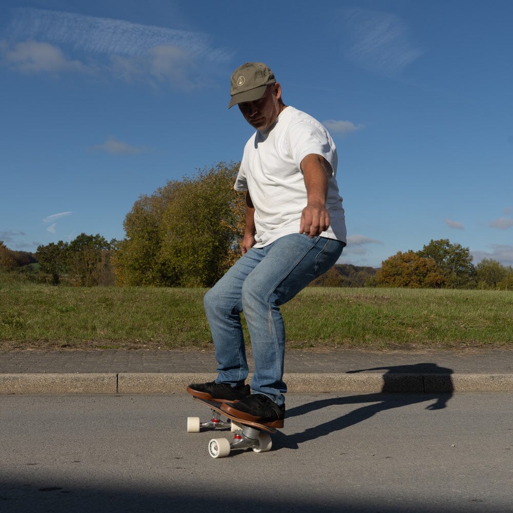 Mann fährt das Surfskate Wood Wave auf der Straße, Surf-Feeling auf Asphalt